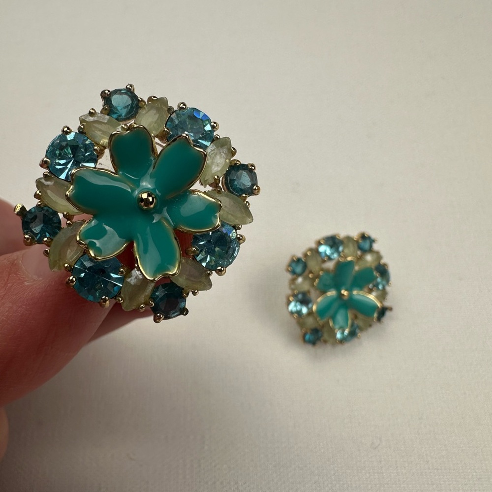 Costume jewelry stud flower earrings surrounded by faux jewels. Blue/teal